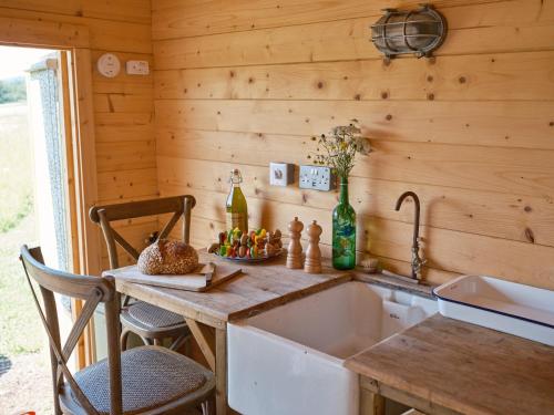 a kitchen with a sink and a wooden wall at The Hoppers Hut in Weald