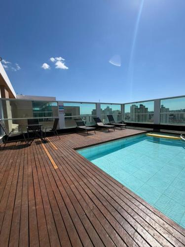 a deck with a swimming pool on top of a building at B&B HOTEL Uberlândia in Uberlândia