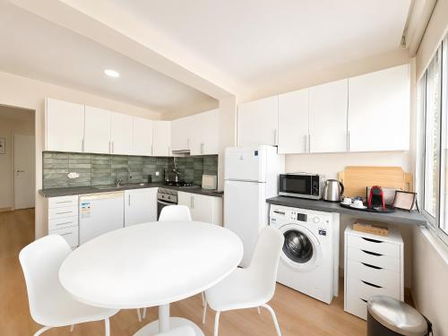 a kitchen with a white table and white appliances at Lovely & Comfy 3 in Estoril