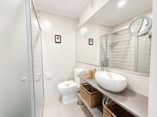 a white bathroom with a sink and a toilet at Lovely & Comfy 3 in Estoril