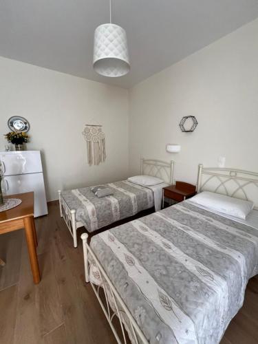 a room with two beds and a table and a table sidx sidx sidx at Elina Apartments in Batsi
