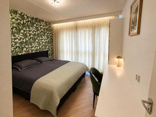a bedroom with a bed and a large window at Reza Almere in Almere