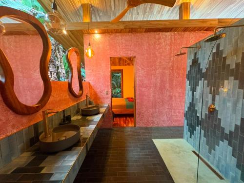 a bathroom with two sinks and two mirrors at Passion Fruit Lodge in Cahuita