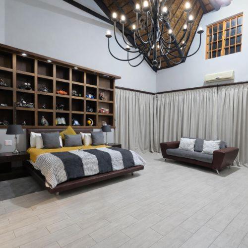 a bedroom with a large bed and a chandelier at Sable Mountain in Hekpoort