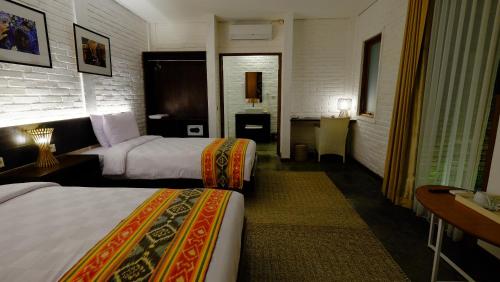 a hotel room with two beds and a desk at Shankara Borobudur in Borobudur