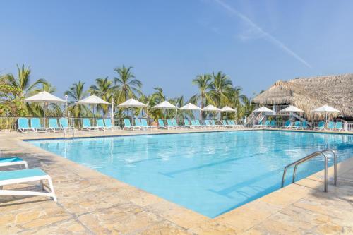 a large swimming pool with chairs and umbrellas at Decameron Galeon - All Inclusive in Santa Marta