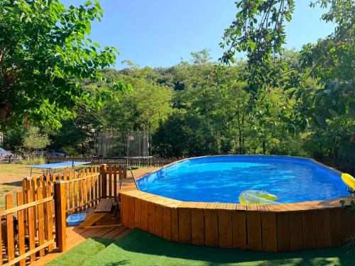a large swimming pool with a wooden fence around it at Le Mas Sylva in La Barriére