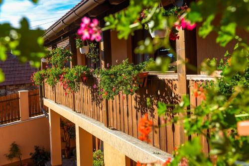 a wooden fence with flowers on it at Nyiko Vendégház in Lupeni