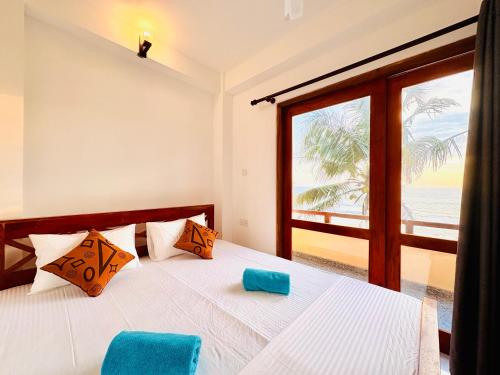 a bedroom with a bed with a view of the ocean at Ayomal Beach Paradise in Galle