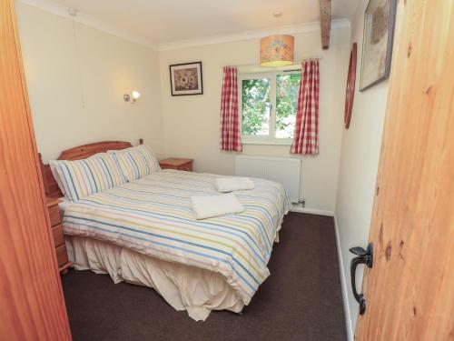 a small bedroom with a bed and a window at Byre Cottage 4 in Pulborough