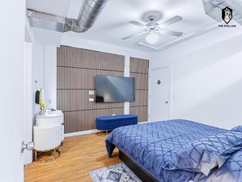 a bedroom with a blue bed and a flat screen tv at The Stallion in Memphis