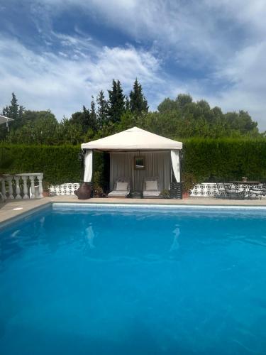 a large blue swimming pool with a gazebo at Finca Malata in Turís
