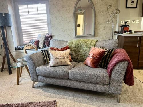 a living room with a couch with pillows on it at The Little Beech Tree in Linlithgow