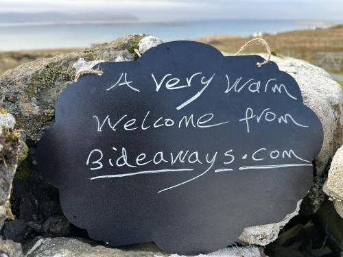 a very warm welcome sign on a rock at Dunhallin Ard in Hallin