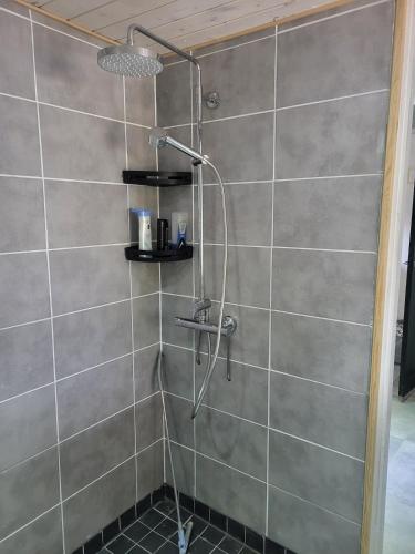 a shower with a shower head in a bathroom at Axelin talo in Iitti