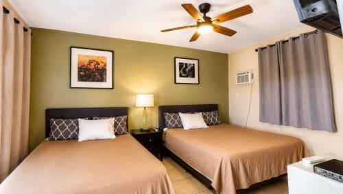a bedroom with two beds and a ceiling fan at Copper Mountain Motel in Superior