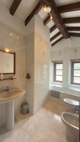 a bathroom with two sinks and a tub and a mirror at Explora Picos de Europa in Cosgaya