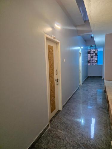 an empty hallway with a door in a room at AJS Elite Rooms in Nagari
