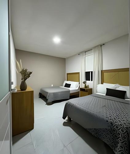 a bedroom with two beds and a television in it at 6-Private Pool and View of Lake Chapala in Chapala