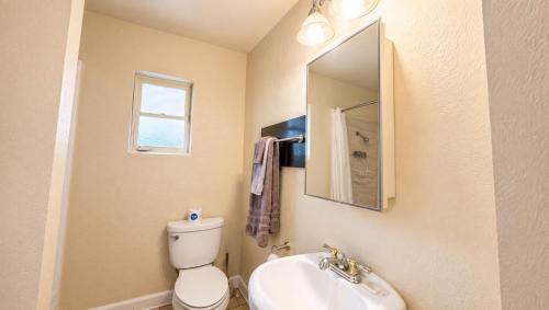 a bathroom with a toilet and a sink and a mirror at Copper Mountain Motel in Superior