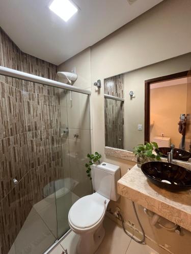 a bathroom with a toilet and a sink and a shower at Lofts Serena - No Centro de Itacaré, a passos da Pituba in Itacaré