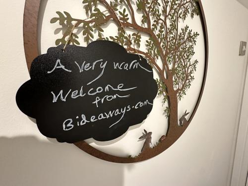 a sign that reads a very warm welcome from a tree at The Canongate Coorie in Jedburgh