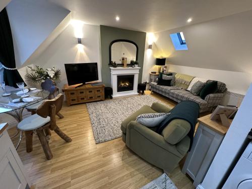 a living room with a couch and a fireplace at The Canongate Coorie in Jedburgh