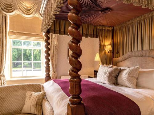 ein Schlafzimmer mit einem Himmelbett mit Baldachin in der Unterkunft Lucknam Park, Emblems Collection in Chippenham
