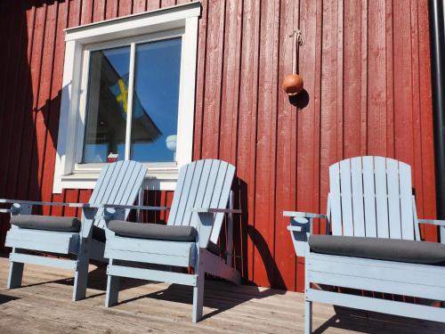 three white chairs sitting next to a red building at StayinDalsland in Dals Långed