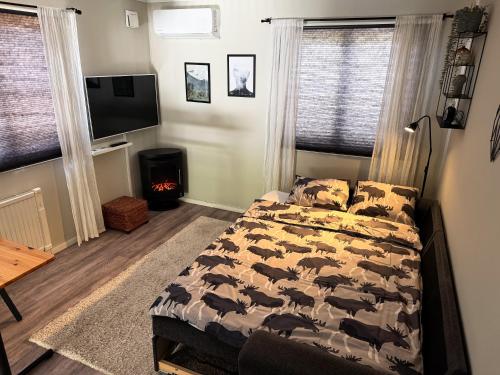 a bedroom with a bed and a flat screen tv at Premium Stuga, Near Göta Canal & Tiveden National Park in Undenäs