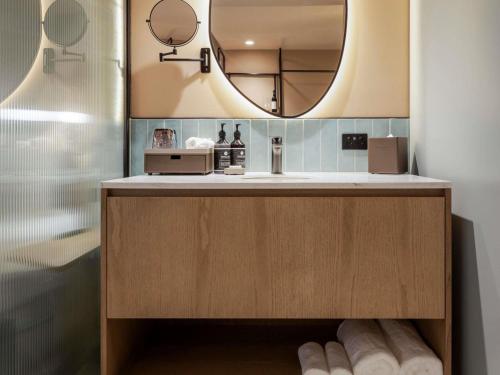 a bathroom with a sink and a mirror at Mercure Melbourne La Trobe Street in Melbourne