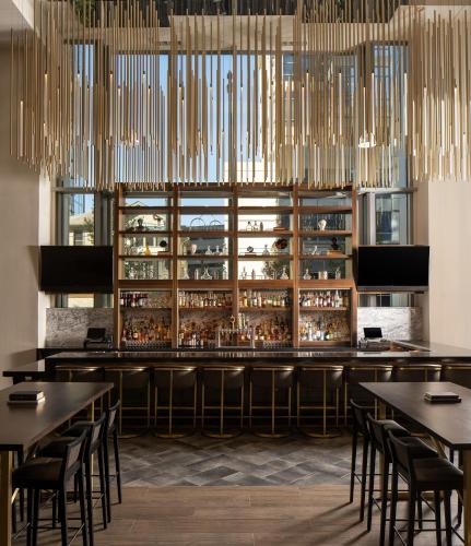 a restaurant with tables and a bar with chandeliers at Epicurean Atlanta, Autograph Collection in Atlanta