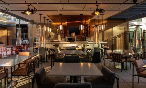 a restaurant with tables and chairs and a bar at Epicurean Atlanta, Autograph Collection in Atlanta
