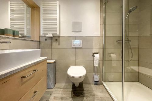 a bathroom with a toilet and a glass shower at Ferienwohnung Bergleuchten in Obermaiselstein