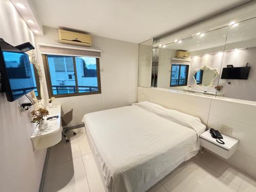 a small bedroom with a bed and a mirror at MC FLATS IPANEMA BEACH STAR in Rio de Janeiro