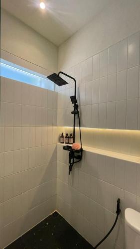 a bathroom with a toilet and a light on the wall at Ivory House in Gantungan