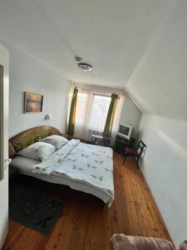 a bedroom with a bed and a wooden floor at Sia Rebir D, Hotel Rebir in Daugavpils