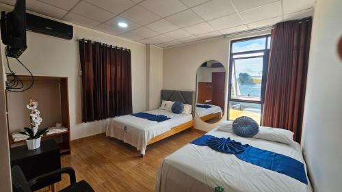 a hotel room with two beds and a window at Trébol Hotel in Yurimaguas