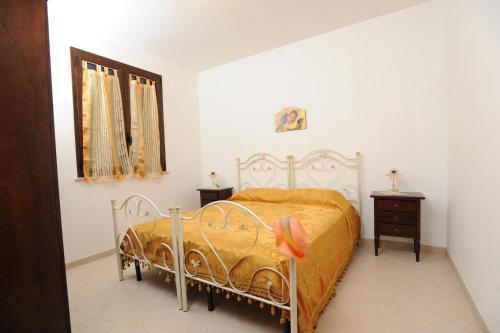 een slaapkamer met een bed met een oranje deken en een dressoir bij Carmelina 3 in Marina di Pescoluse