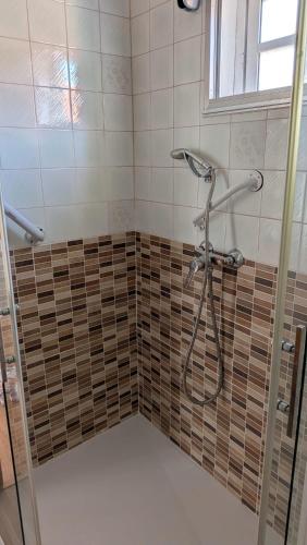 a shower in a bathroom with brown tile at Casa da Cerca in Cenlle