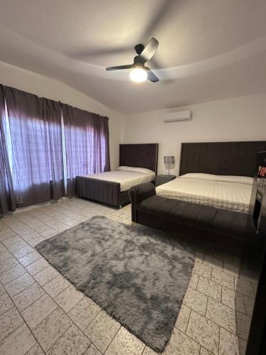 a bedroom with two beds and a ceiling fan at Hotel H Galería Club in Tuxtla Gutiérrez