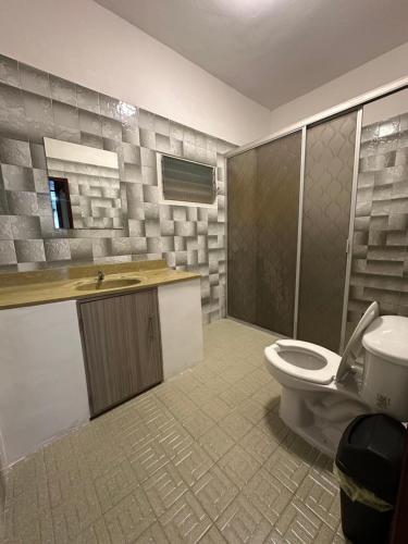a bathroom with a toilet and a sink at Hotel H Galería Club in Tuxtla Gutiérrez