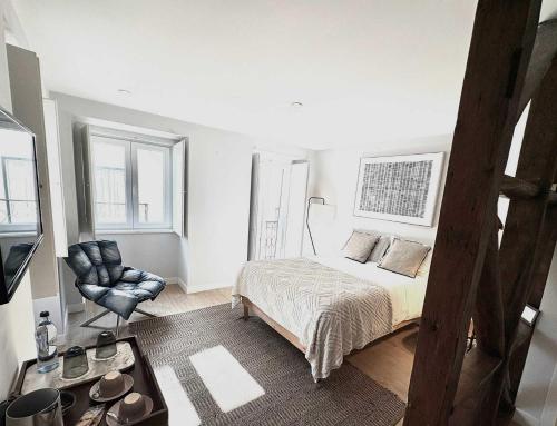 a bedroom with a bed and a chair at Bairro House Lisbon Charming Suites in Lisbon