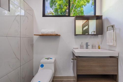 a bathroom with a sink and a toilet and a mirror at Z orro Tropical in Arbolito