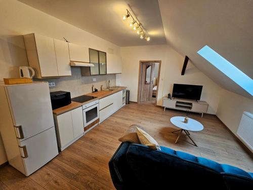 a living room with a couch and a kitchen at Útulný podkrovný apartmán, Pet Friendly in Martin
