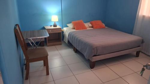a bedroom with a bed and a desk and a chair at Hostal Mejillones in Mejillones