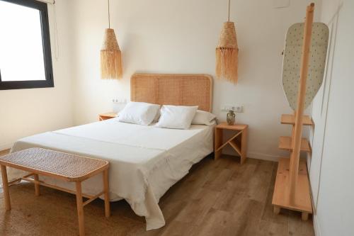 a bedroom with a white bed and two tables at Apartaments Bellreguard in Papiol