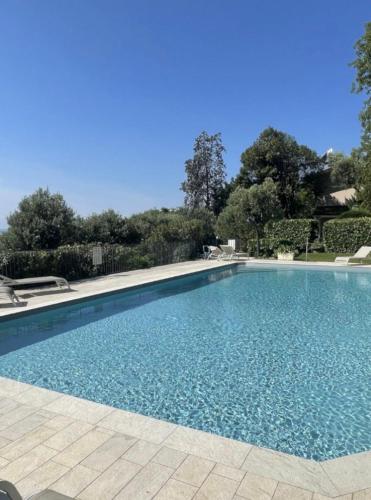 a large swimming pool with blue water at Villa Francesca Toscolano in Toscolano Maderno