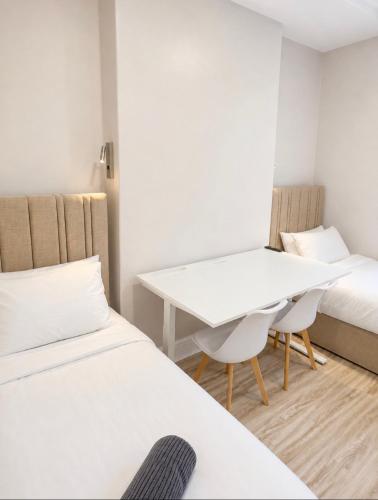 a small room with two beds and a table at Central Room to Rent in Plymouth