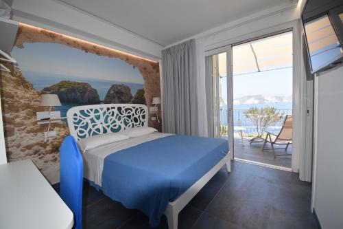 a bedroom with a blue bed and a view of the ocean at AzzurroMare Ponza Rooms Sea View by Caseaponza it in Ponza